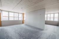 Wohnung im Rohbauzustand. Noch wird gebaut. Der Anhydritboden mit Bodenheizung und die Holzdecke sind jedoch bereits weitgehend fertiggestellt.