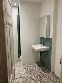 Blick in ein Bad mit Dusche. Die Bäder wurden vergrössert. Der bestehende Terrazzo-Boden wurde ergänzt.